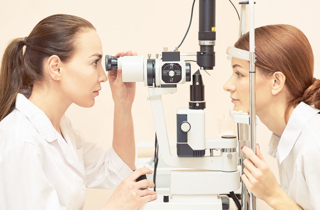 Women undergoing eye exam by her optometrist at clinic.
